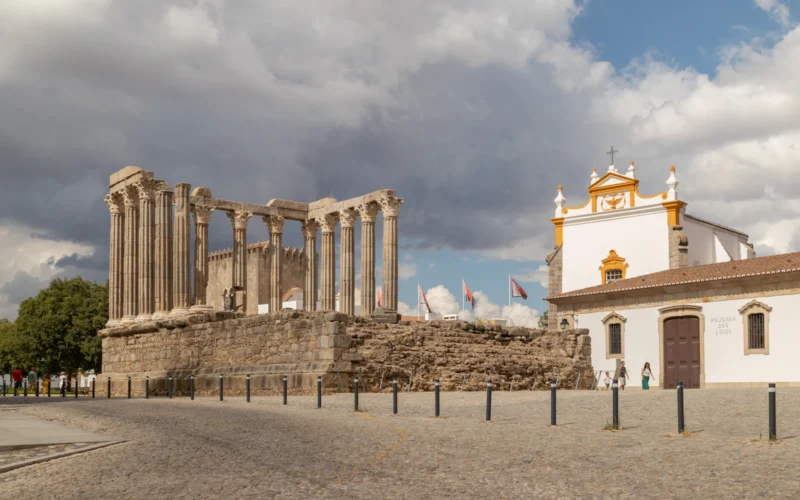 Colunas do Templo Romano de Évora sob um céu com nuvens
