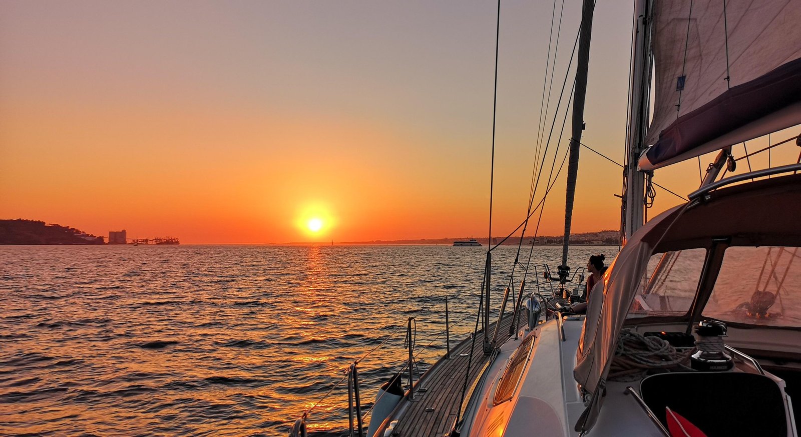View from a sailing boat towards the sunset over Lisbon waters