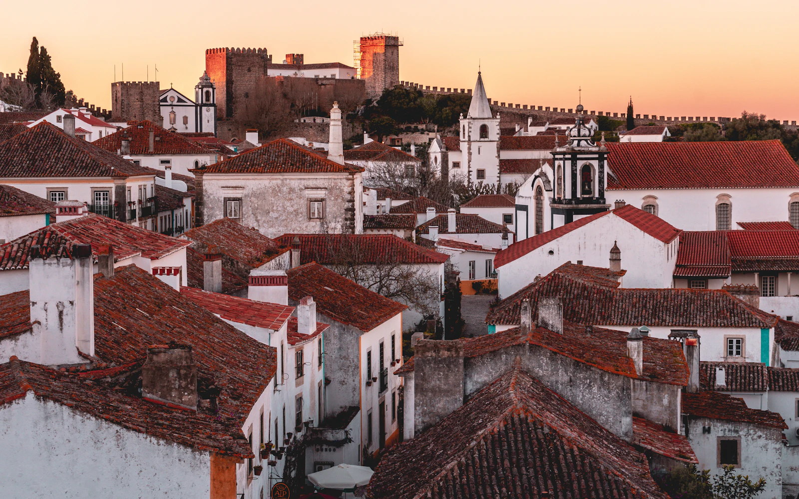 Castelo, muralhas e telhados de Óbidos à luz do pôr do sol