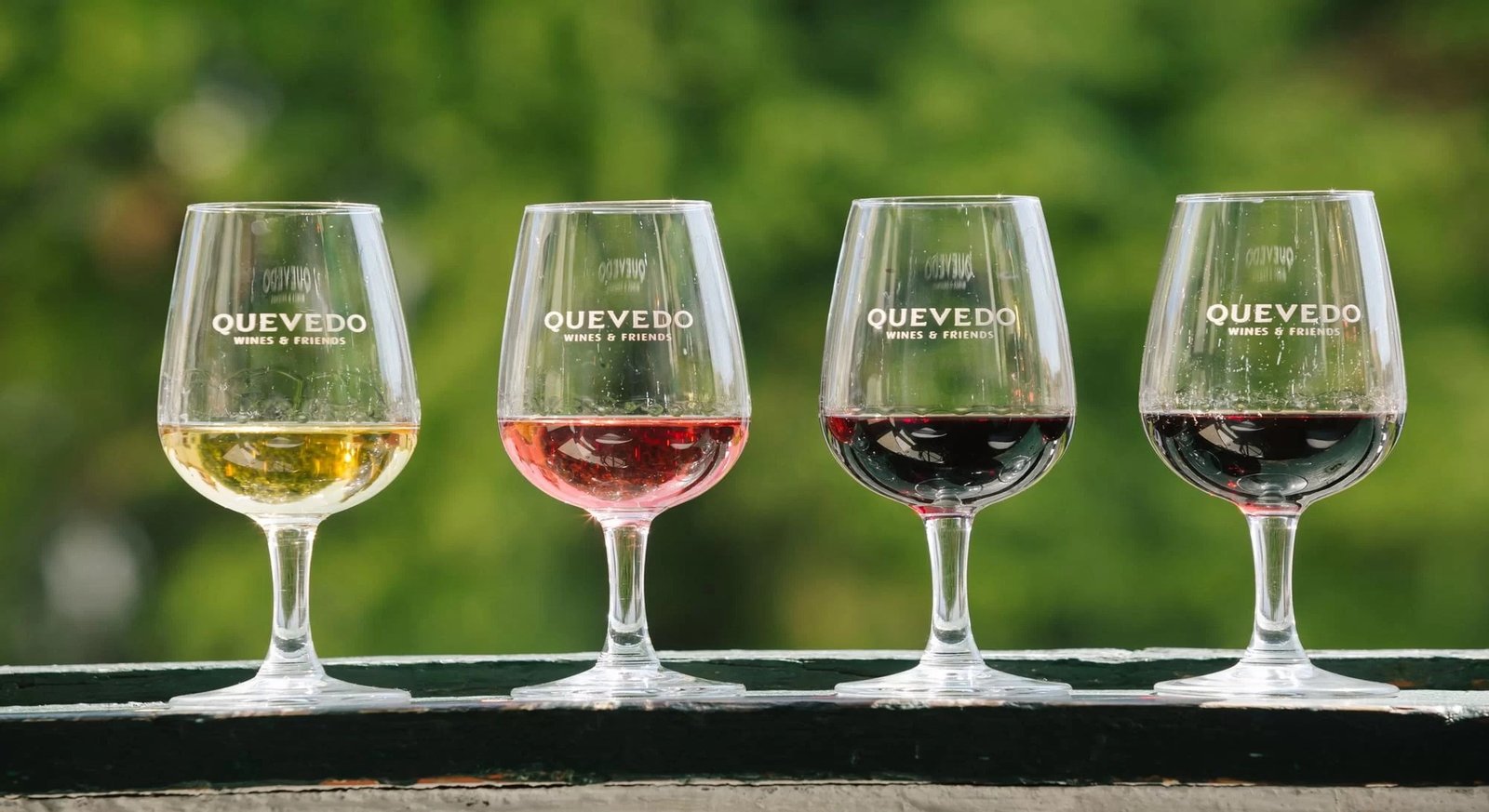 Quatro copos com diferentes vinhos numa mesa de prova