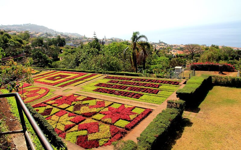 Geometric red and yellow flower beds overlooking Funchal at Madeira Botanical Garden