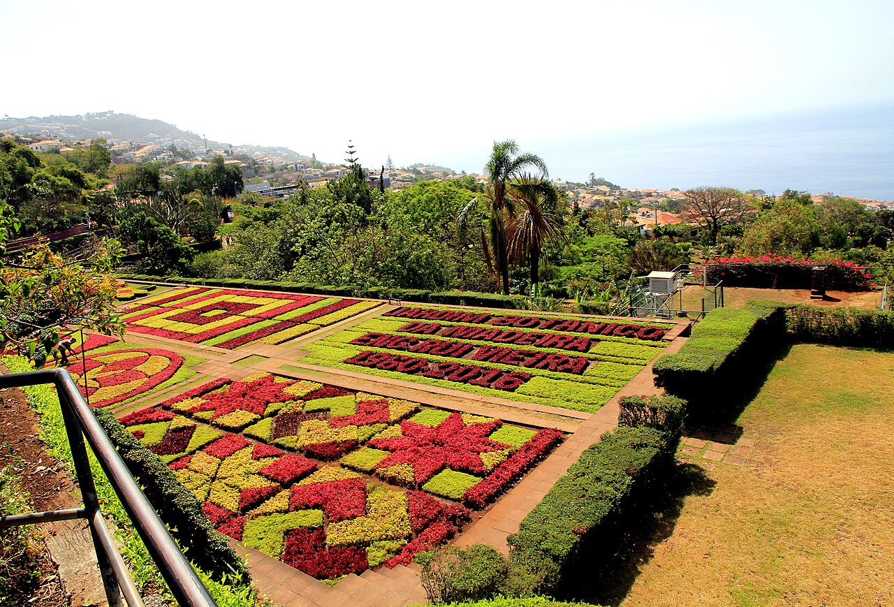 Geometric red and yellow flower beds overlooking Funchal at Madeira Botanical Garden