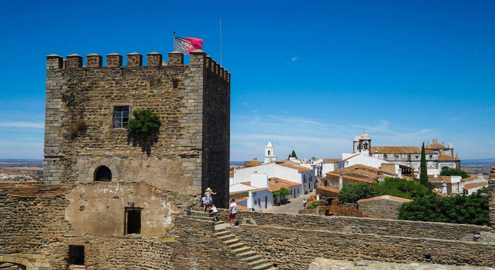 Casas encaladas y murallas del castillo de Monsaraz en lo alto de la colina