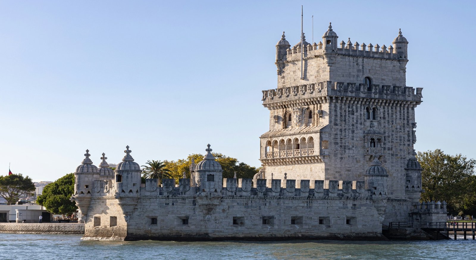 Torre de Belém iluminada al atardecer junto al río Tajo en Lisboa