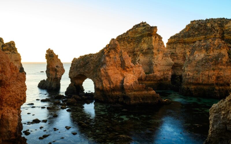 Limestone sea stacks and a natural arch at Ponta da Piedade near sunrise