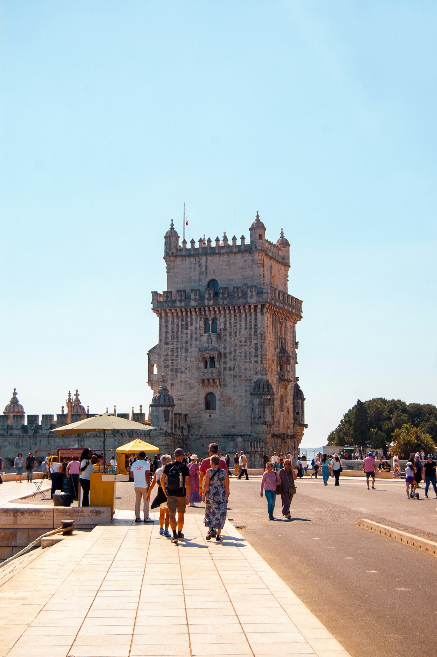 Visitors walking towards Belém Tower in Lisbon.