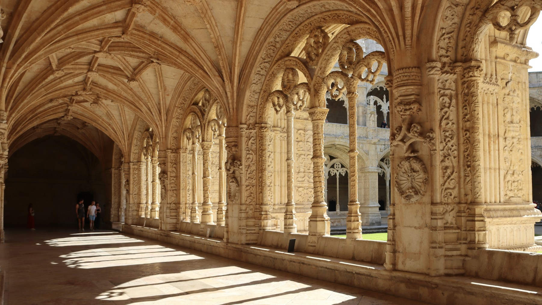 A long arched corridor in the cloister of Jerónimos Monastery.