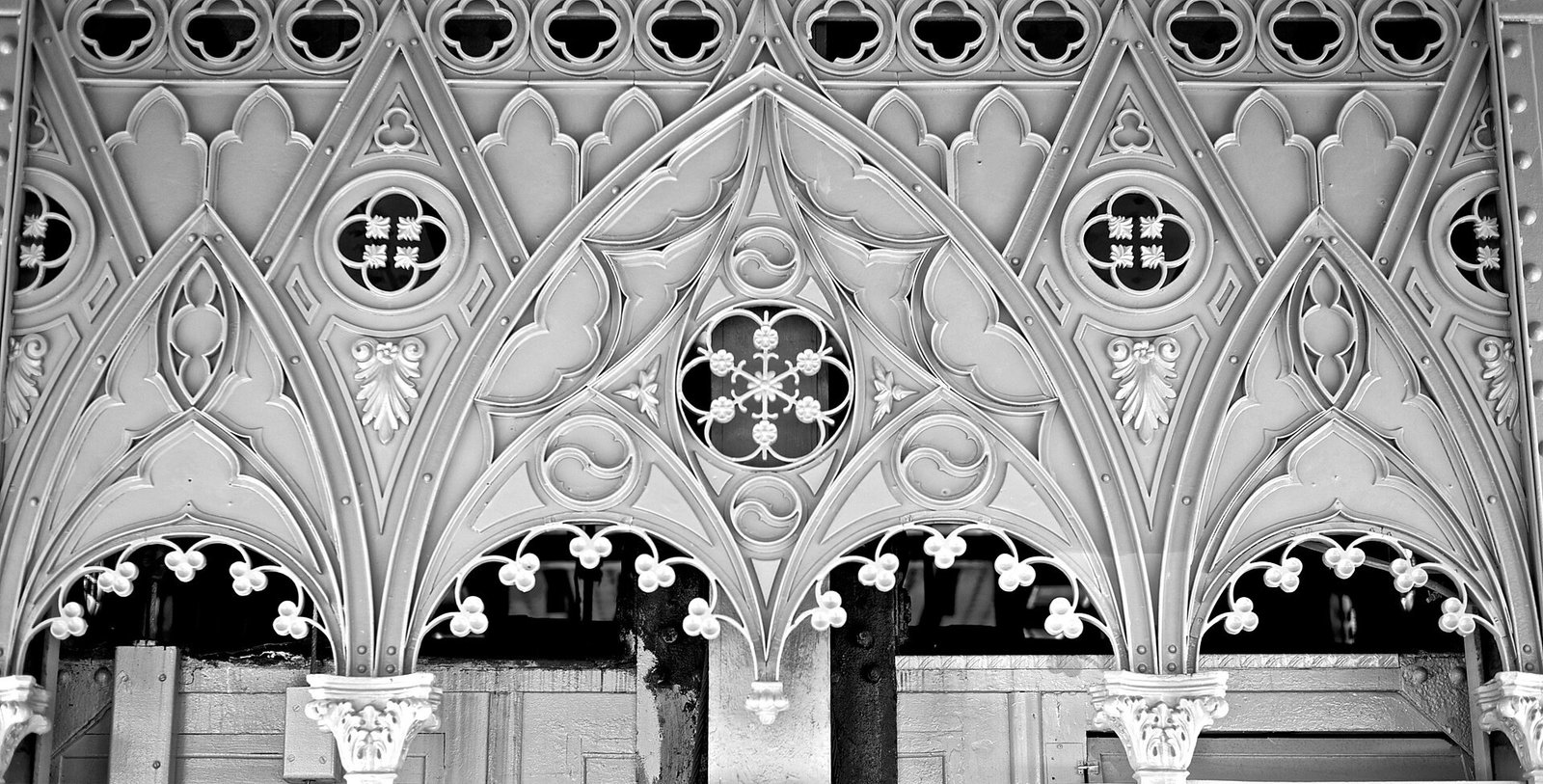 Black-and-white detail of ornamental iron arches on Lisbon’s Santa Justa Lift