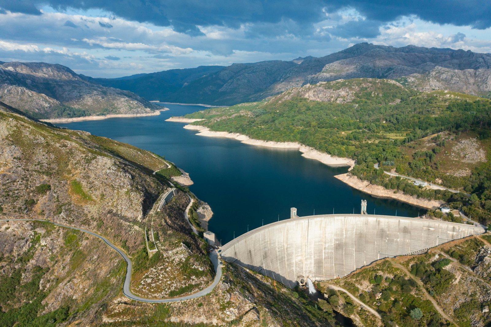 Reservoir, curved dam and granite mountain slopes in Gerês
